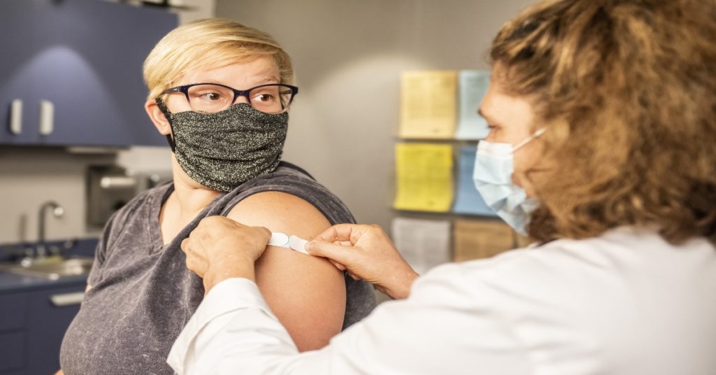 Woman getting a vaccine at a travel clinic
